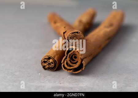 Zimt-Sticks nach unten auf einem grauen Schiefer Textur Hintergrund Nahaufnahme Makrowinkel geführt Stockfoto
