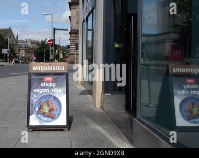 NOTTINGHAM, GROSSBRITANNIEN - 29. Jul 2021: Das Schild von Wagamama auf dem Bürgersteig vor ihrem Restaurant in Nottingham Stockfoto