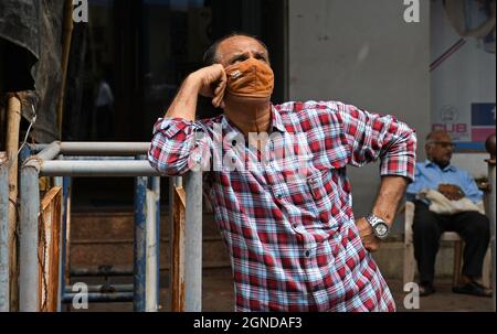 Mumbai, Indien. September 2021. Ein Mann, der eine Schutzmaske trägt, sieht sich vor der Bombay Stock Exchange in Mumbai die Sensex News an.Sensex hat zum ersten Mal das Niveau von 60,000 überschritten. Kredit: SOPA Images Limited/Alamy Live Nachrichten Stockfoto