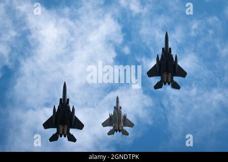 Ein F-15C Eagle der US-Luftwaffe zieht sich von zwei F-15E-Schlagadlern ab, während er eine fehlende Mannformation zu Ehren des Battle of Britain Day über die Royal Air Force Lakenheath, England, am 24. September 2021 durchführt. Der Battle of Britain Day erinnert an den größten deutschen Angriff auf Großbritannien während des Zweiten Weltkriegs, bei dem die Luftwaffe hoffte, die britische Royal Air Force zu vernichten, was zu einem überwältigenden Sieg der RAF und einem Stopp der deutschen Invasionspläne führte. (USA Luftwaffe Foto von Senior Airman John Ennis) Stockfoto