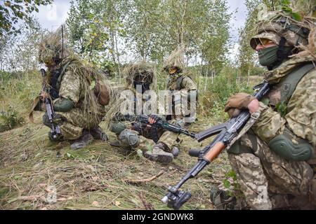 Lviv, Ukraine. September 2021. Ukrainisches Militär, das während der internationalen Militärübungen „Rapid Trident - 2021“ im Gras verkleidet wurde, auf dem Territorium des Internationalen Zentrums für Friedenssicherung und Sicherheit der Nationalen Akademie der Landstreitkräfte, benannt nach Hetman Petro Sahaidachny, Ukrainisch-amerikanische Kommando- und Stabsübungen mit Truppen "Rapid Trident - 2021" finden statt, die am 20. September begonnen haben und bis zum 1. Oktober 2021 dauern werden. An den Übungen nehmen Soldaten aus 15 Ländern Teil (Ukraine, USA, Deutschland, Bulgarien, Georgien, Italien, Polen, Rumänien, Großbritannien und andere Stockfoto