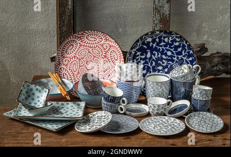 Verschiedene Keramikplatten, Schale und Tasse auf Holztisch. Keramikgeschirr, schöne Einrichtung, selektiver Fokus. Stockfoto