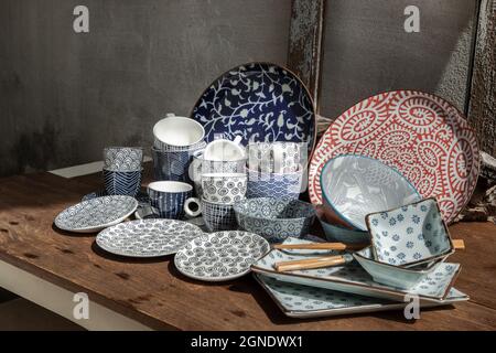 Verschiedene Keramikplatten, Schale und Tasse auf Holztisch. Keramikgeschirr, schöne Einrichtung, selektiver Fokus. Stockfoto