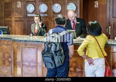 Melbourne Australien, Hilton on the Park Hotel, Lobby Gäste Rezeption Einchecken Reservierungen anmelden, Frau Mann Paar Uhren verschiedenen Zeitzonen Stockfoto