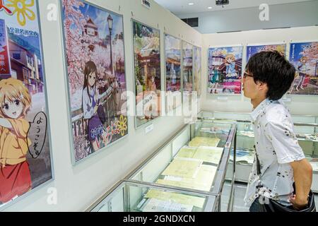 Tokyo Japan, Akihabara, Tokyo Anime Center Ausstellung Sammlung, asiatische Jungen suchen Film Plakate Filme Zeichentrickfiguren Japanisch Stockfoto