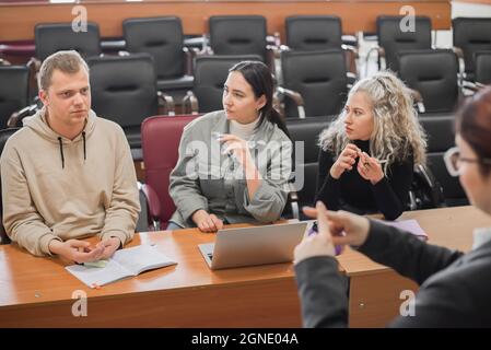 Der Lehrer und die Schüler kommunizieren in Gebärdensprache im Klassenzimmer. Hörgeschädigte und taube Menschen Stockfoto