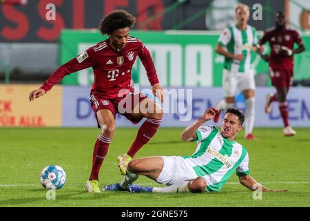 Fürth, Deutschland. September 2021. Leroy Sane (L) von Bayern München steht mit Marco Meyerhoefer von Fürth während eines Bundesliga-Spiels zwischen der SpVgg Greuther Fürth und Bayern München am 24. September 2021 in Fürth auf dem Spiel. Quelle: Philippe Ruiz/Xinhua/Alamy Live News Stockfoto