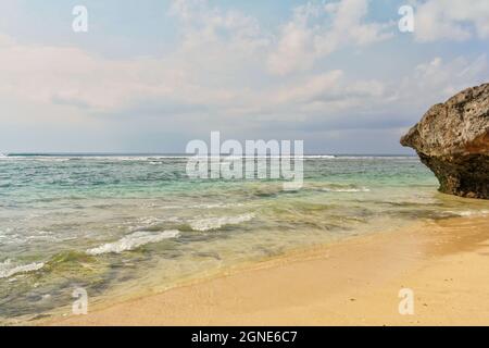 Leere tropische Strandlandschaft mit türkisfarbenem klarem Wasser und wolkig blauem Himmel im Hintergrund. Keine Personen. Stockfoto