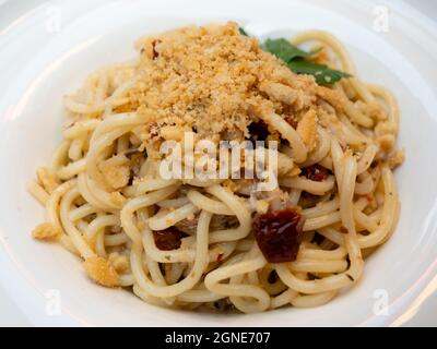 Bigoli Pasta Con Sarde di Lago, Pomodori Secchi e Briciole, Spaghetti-Nudeln mit Sardinen vom Gardasee, sonnengetrocknete Tomaten und Breadcrumbs Stockfoto