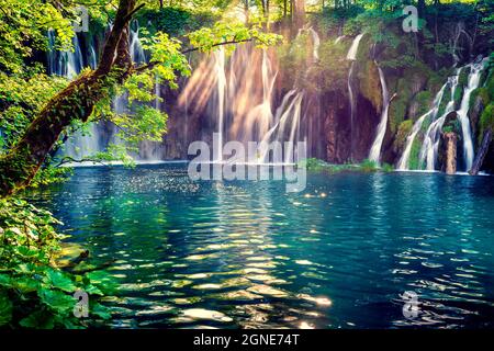 Letztes Sonnenlicht erhellt den reinen Wasserfall im Plitvice National Park. Bunte Frühlingsszene von grünem Wald mit blauem See. Tolle Landschaft vi Stockfoto