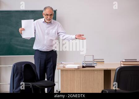 Alte Lehrerin vor der Tafel Stockfoto