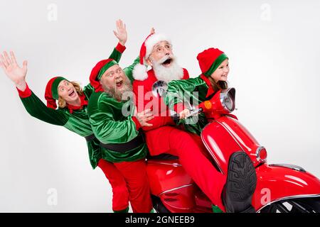 Profil Foto von verrückten Team vier Menschen fahren Moped haben Party Spaß tragen santa Elf Kostüm isoliert grauen Hintergrund Stockfoto