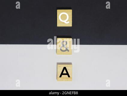 Holzalphabetsteine mit Q und Einem Buchstaben auf schwarzem und weißem Papier. Konzept der Frage und Antwort Q und Einer Online-Hilfe Stockfoto