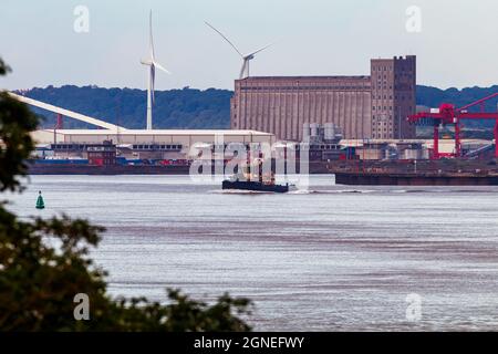 Schlepper verlässt Portbury Docks mit Wassereinlasskammern für Hinkley Point C im Hintergrund Stockfoto