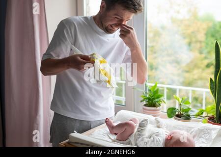 Kaukasischer Vater, der sich um seine neugeborene Tochter oder seinen Sohn kümmert, der die Windel wechselt Stockfoto