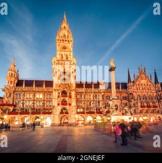 Beeindruckende Abendansicht des Marienplatzes - zentraler Platz & Verkehrsknotenpunkt mit imposanten Petersdom, zwei Rathäusern und einem Spielzeugmuseum, München, Stockfoto