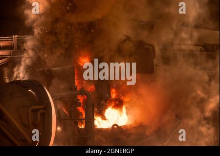 Lichtbogenofen während des Betriebs. Es gibt viel Rauch und Feuer Stockfoto