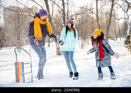 Foto in voller Größe von glücklich gute Laune ziemlich positive Familie Mutter Vater und Tochter genießen Winterurlaub Schneewerfen Stockfoto