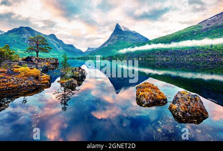 Unglaublicher Sommeraufgang auf dem Innerdalsvatna See. Bunte Morgenszene in Norwegen, Europa. Schönheit der Natur Konzept Hintergrund. Beitrag zum künstlerischen Stil Stockfoto