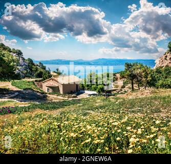 Sonnige Frühlingsszene der Agios Ioannis-Kirche. Herrliche Morgenansicht des Westgerichts von Heraion von Perachora, Limni Vouliagmenis Lage, Griechenland, Europa. Stockfoto