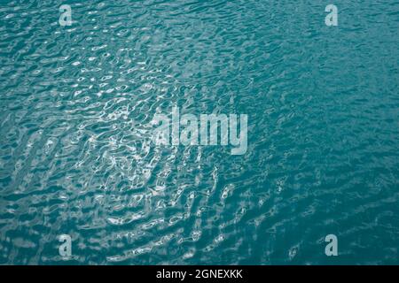 Türkisblaue Wasser Textur und Reflexionen von Sonnenlicht abstrakten Natur Hintergrund für Entspannung Stockfoto