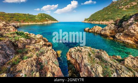 Sonniger Frühlingsblick auf Pirates Bay, Porto Timoni, Afionas Dorflage. Wunderschöne Morgenseeküste des Ionischen Meeres. Fantastische Außenaufnahme von Korfu i Stockfoto