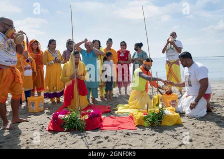 Hindu-Gläubige bringen ihren Göttern und Göttinnen bei einem Ganga- und Kateri-Amma Poosai-Gottesdienst in Jamaica Bay in Queens, New York City, Opfergaben zu. Stockfoto