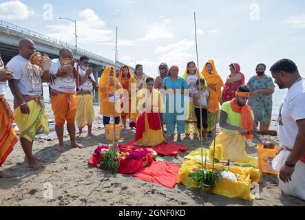 Hindu-Gläubige bringen ihren Göttern und Göttinnen bei einem Ganga- und Kateri-Amma Poosai-Gottesdienst in Jamaica Bay in Queens, New York City, Opfergaben zu. Stockfoto