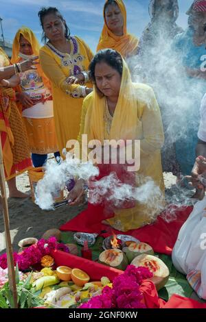 Hinduistische Frauen opfern ihren Göttern und Göttinnen bei einem Ganga- und Kateri-Amma Poosai-Gottesdienst an der Jamaica Bay in Queens, New York City. Stockfoto