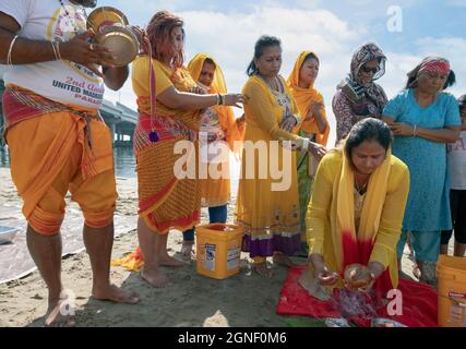 Hindu-Gläubige bringen ihren Göttern und Göttinnen bei einem Ganga- und Kateri-Amma Poosai-Gottesdienst in Jamaica Bay in Queens, New York City, Opfergaben zu. Stockfoto