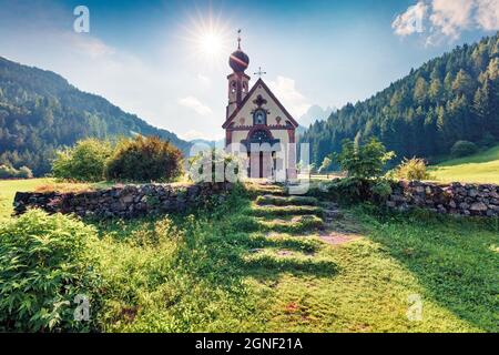 Herrliche Morgenansicht der Kirche San Giovanni im Dorf St. Magdalena. Sonnige Sommerszene im Villnob-Tal mit den Bergen der Geisler-Gruppe auf dem Rücken Stockfoto