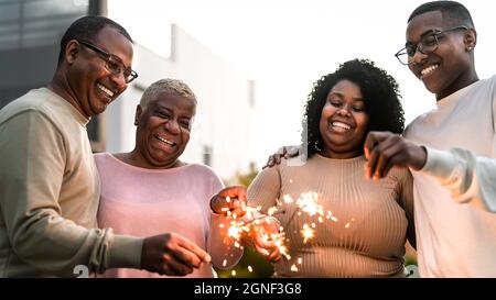 Glückliche afrikanische Familie feiert Urlaub mit Wunderkerzen Feuerwerk auf Haus Party Stockfoto