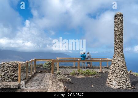 Ein paar Touristen beobachten die Landschaft vom Aussichtspunkt La Peña aus. El Hierro Kanarische Inseln. Stockfoto