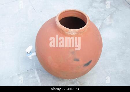 Selektiver Fokus auf TONKRUG MIT KUNSTSTOFFHAHN. Handgemachtes indisches Handwerk. Dorfleben. Stockfoto