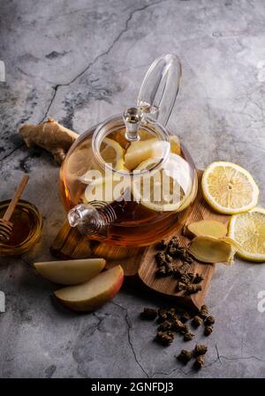 Selektiver Fokus, frisch gebrühter Tee in einer transparenten Teekane, mit Früchten und frischen Beeren. Blatttee und Gewürze. Stillleben. Für Werbung und Menüs Stockfoto