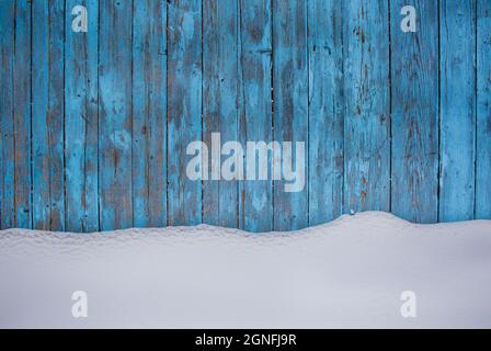Blauer Holzstruktur Hintergrund mit unberührtem Schnee, abblätternde Farbe auf Holz im Winter Stockfoto