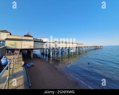 Teignmouth, Devon, Großbritannien, 21. Juli 2021 : der Grand Pier, auch bekannt als Teignmouth Pier an der Küste, ist ein beliebtes Touristenziel für Urlaubsreisen Stockfoto