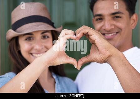 Portrait von glücklichen Paar macht Herz Form Zeichen mit Händen. Happy adult paar verlieben machen Herzform Symbol mit Händen. Romantisch liebend Stockfoto