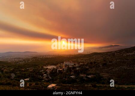 Athen Blick bei Sonnenuntergang mit roten und gelben Wolken vom Penteli Berg. Griechenland. Stockfoto