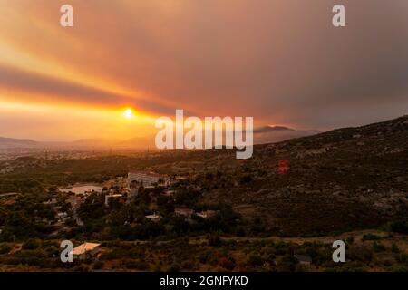 Athen Blick bei Sonnenuntergang mit roten und gelben Wolken vom Penteli Berg. Griechenland. Stockfoto