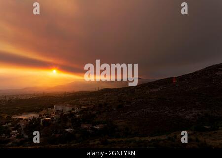 Athen Blick bei Sonnenuntergang mit roten und gelben Wolken vom Penteli Berg. Griechenland. Stockfoto