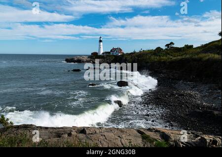 Bei Flut stürzen die Wellen über den felsigen Strand am Portland Head Leuchtturm in Maine. Es ist das älteste Leuchtfeuer in Maine. Stockfoto