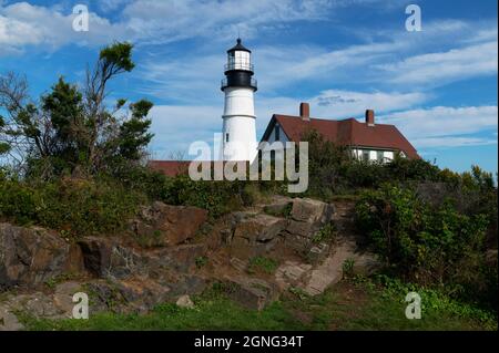 Wildblumen und Sträucher hinter dem Portland Head Leuchtturm in Maine, der an einem Sommertag auf felsigen Böden wächst. Es ist Maine's ältestes Leuchtfeuer. Stockfoto