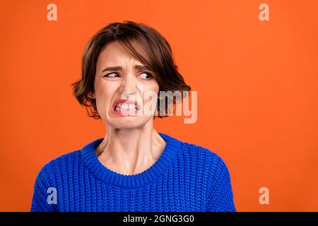 Foto Porträt bob behaarte Frau angewidert suchen Copyspace isoliert lebendige orange Farbe Hintergrund Stockfoto