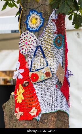 Gehäkelte Strickwaren schmücken die Bäume am 14.. Internationale Roots und akustische Musik beim Gate to Southwell Music Festival. Stockfoto