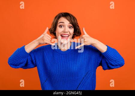 Foto Porträt bob behaarte Frau lächelnd zeigt rufen Sie mich Zeichen isoliert lebendige orange Farbe Hintergrund Stockfoto