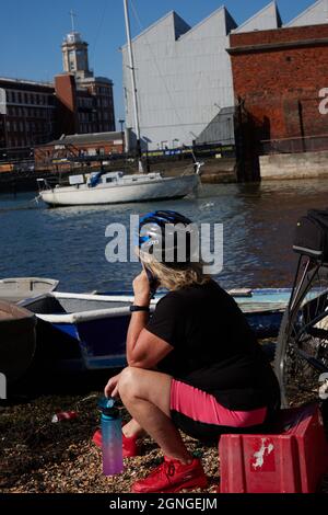 Radfahrerin gesehen, wie sie sich im Hafen von Portsmouth ausruhte. Stockfoto