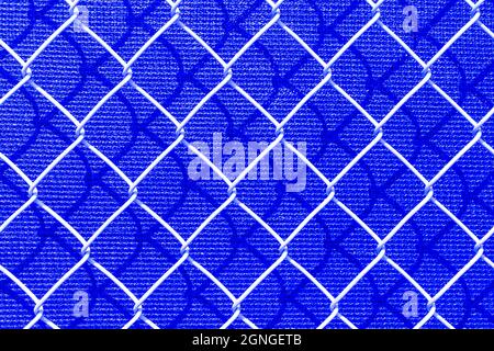 Abstrakter blauer Hintergrund zeigt ein Makro eines Kettengliederzauns. Stockfoto