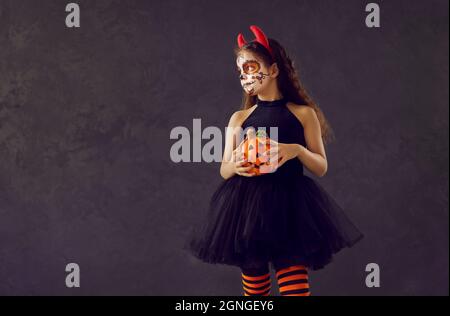 Porträt eines Mädchens mit Halloween Schädel Make-up steht auf dunklen Kopie Raum Hintergrund Stockfoto