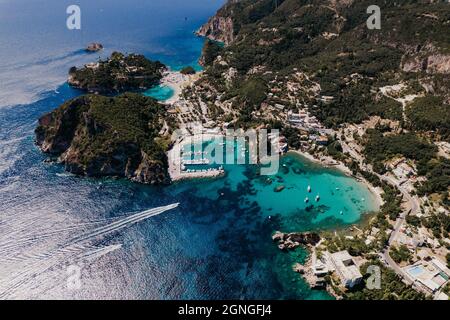 Luftdrohnenansicht zur Bucht von Paleokastritsa, herzförmige Küste mit klarem blauem Meerwasser. Griechenland Korfu Insel. Luxusresort Dorf, Boote, Yachten Stockfoto